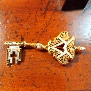 Gold colored key brooch in like new condition